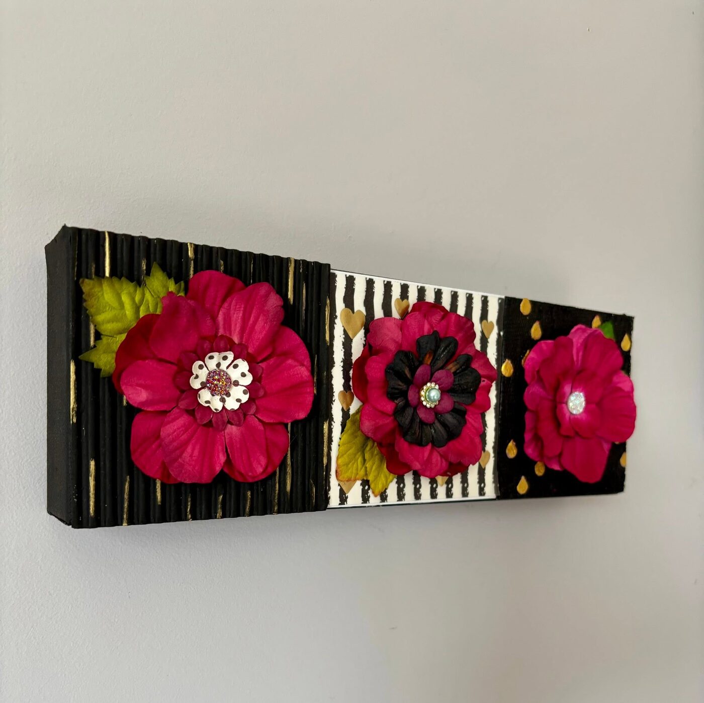 Triptych of handmade paper flowers on striped panels