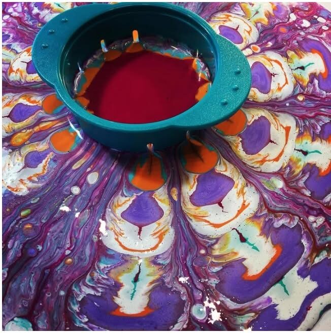 A fluid pour in progress, paint flowing from a pour tool